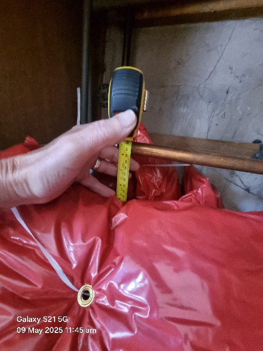 Energy assessor measuring insulation on a hot water cylinder during an Energy Performance Certificate survey in Doncaster.